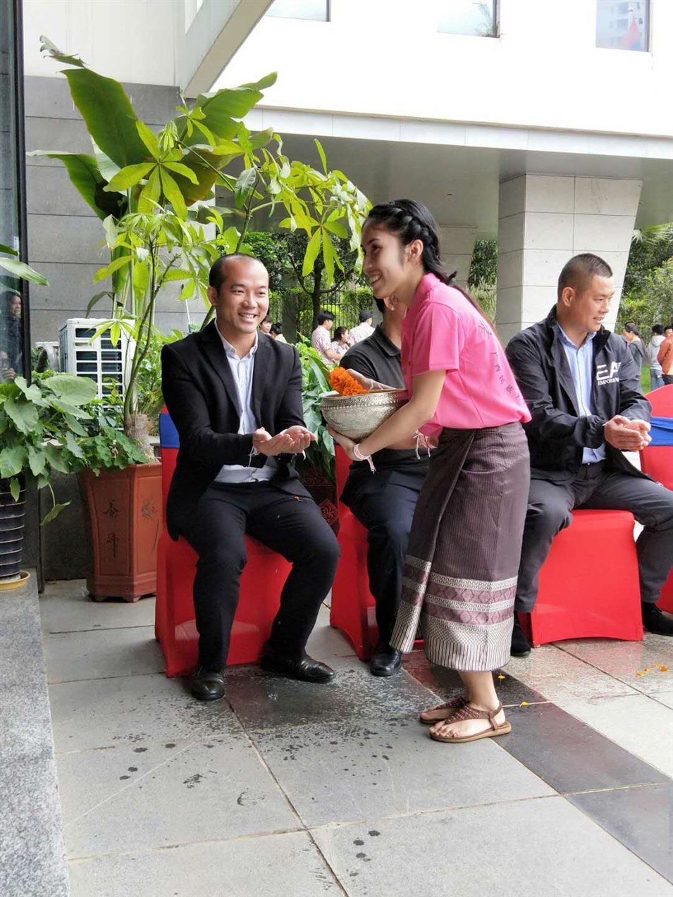 老撾駐廣西留學(xué)生代表將浸有花瓣的香水灑客人的手上，表示對(duì)嘉賓的美好祝福（圖一）